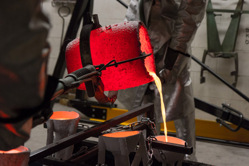 pouring liquid bronze into a cast