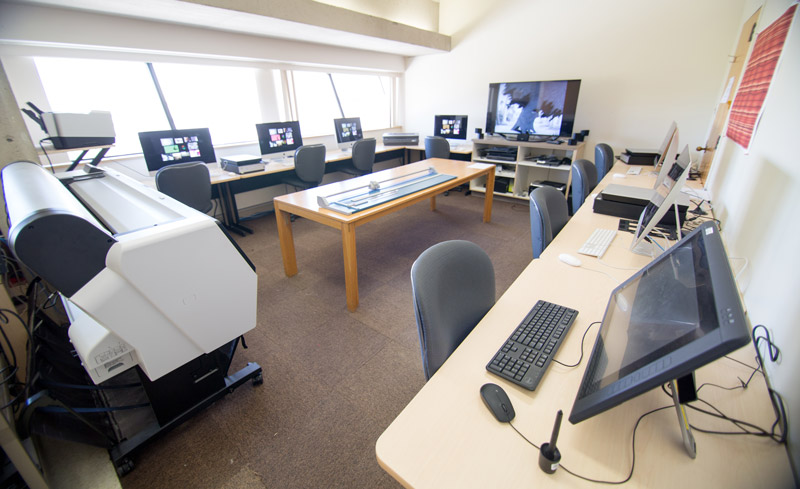 Room with computer workstations, tablets, and printers