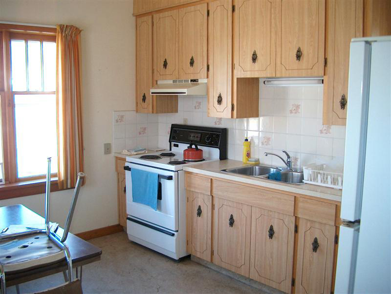 fully stocked kitchen with stove, fridge, and cupboards