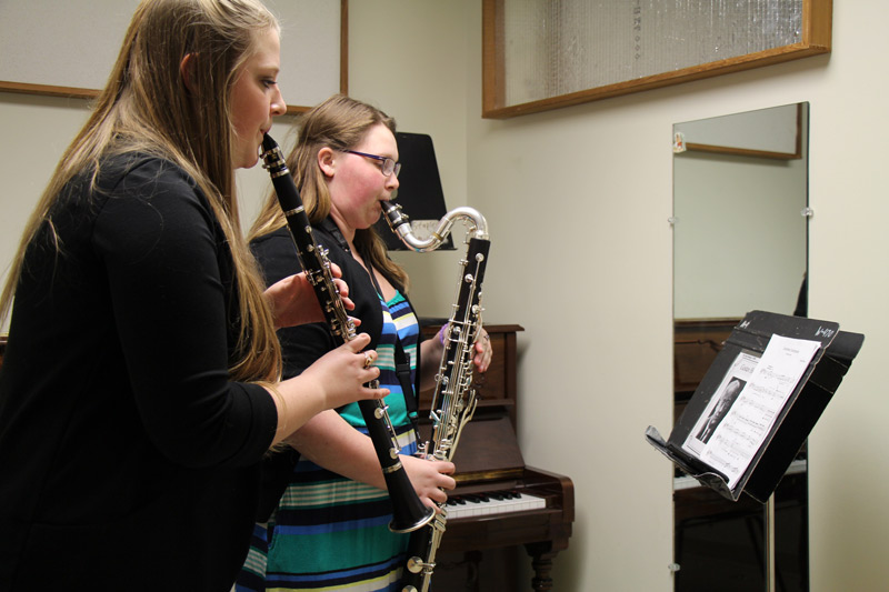 Students playing clarinet and bass clarinet in practice room