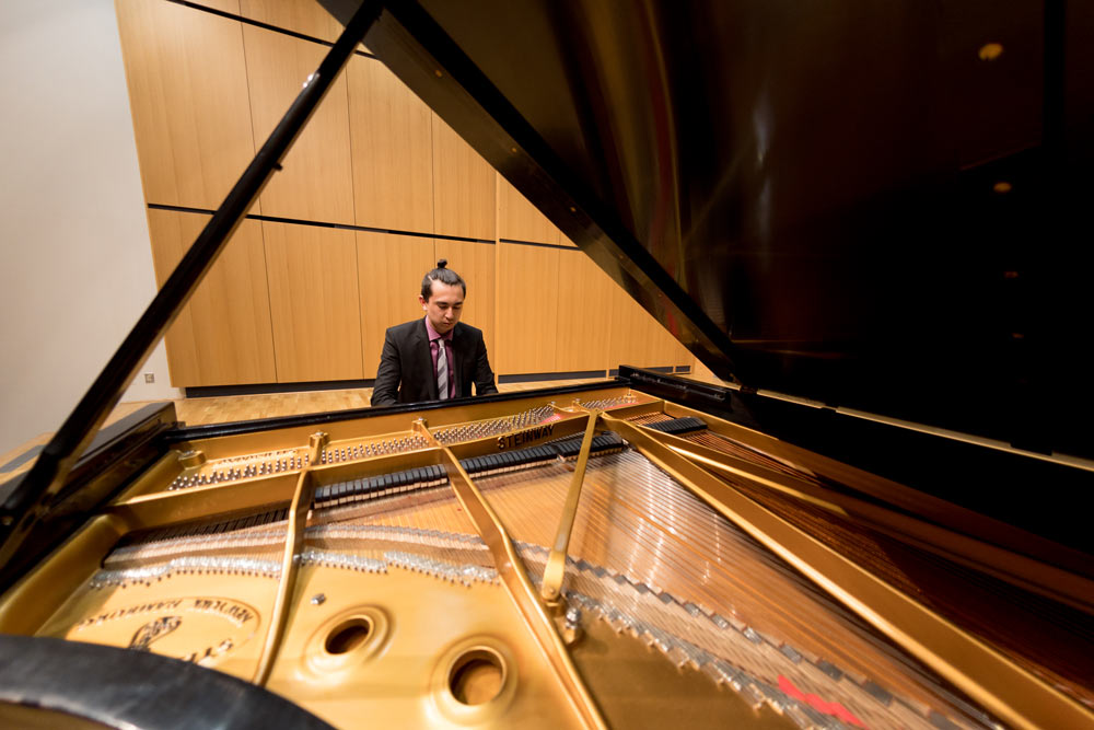 Student playing piano in the recital hall