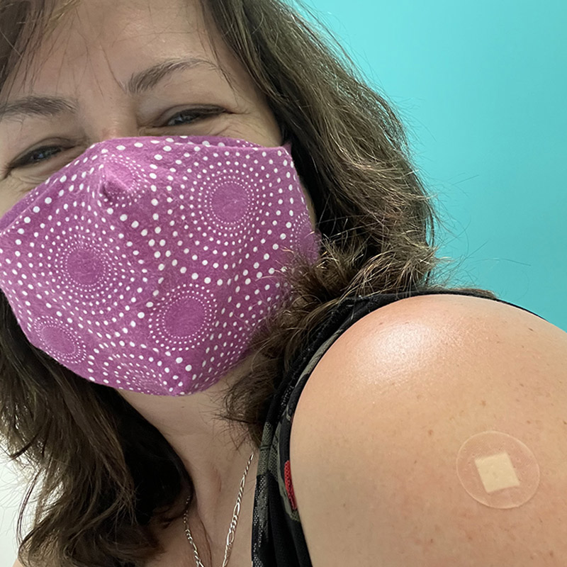 Woman with band aid on arm from vaccine