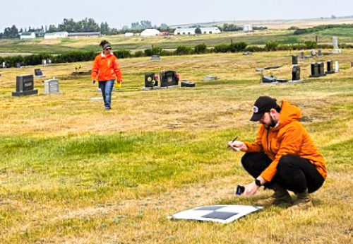 Researchers in a rural cemetery collecting data