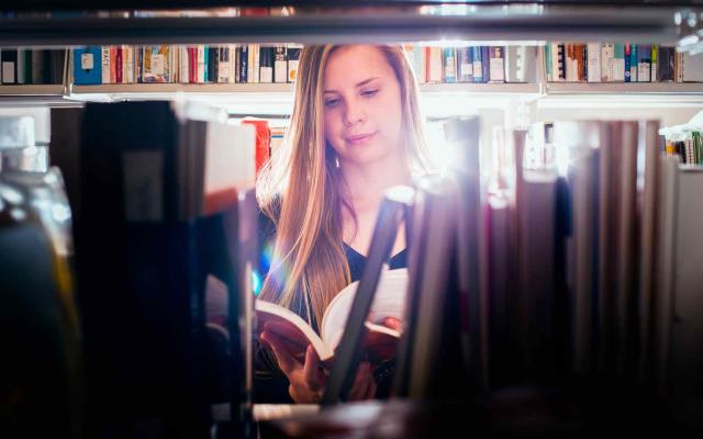 Student looking at books in the Library