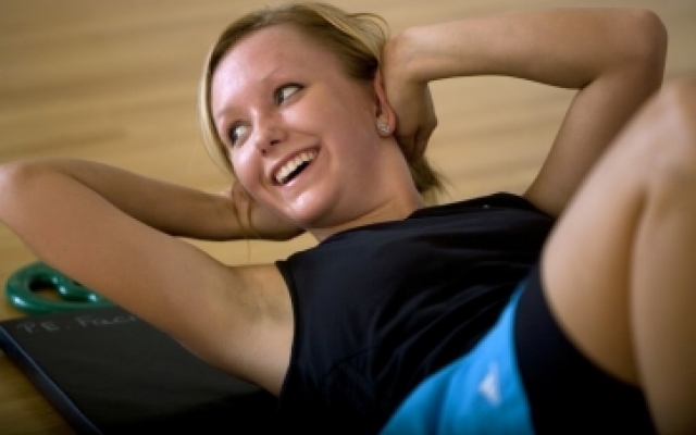 woman smiling while doing crunches