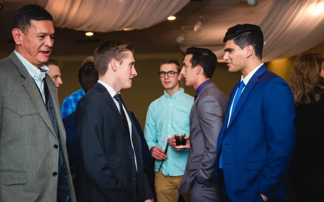 Students dressed in suits networking