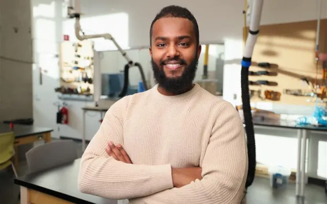 Man standing in a workshop with arms crossed across his chest