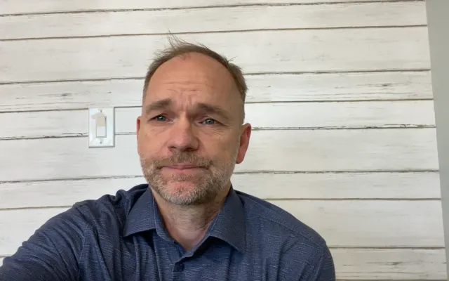 Man in front of a white wooden wall