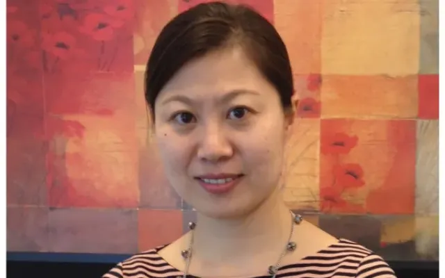 Gloria wearing a striped shirt and a necklace.