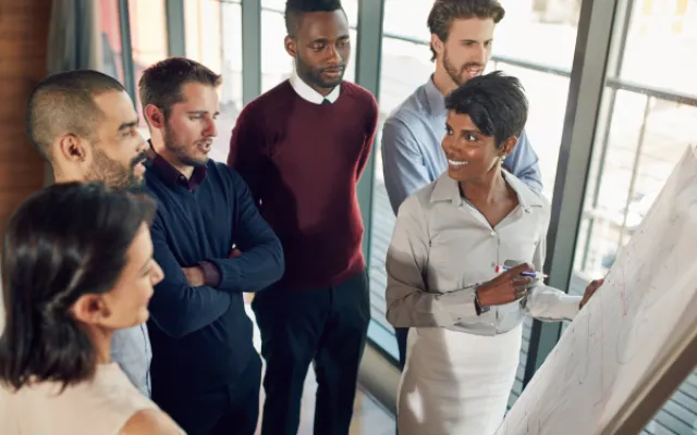 6 people standing at a flip chart