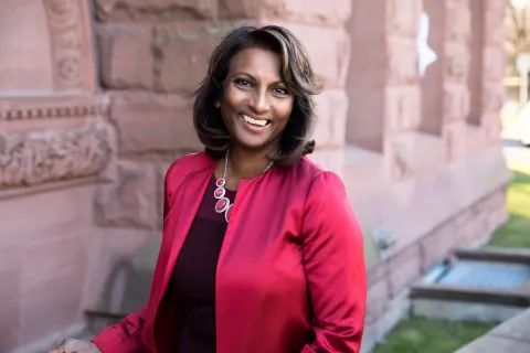 The Honourable Indira Naidoo-Harris, (BASc (BA) '82), ECO stands in front of a brick wall