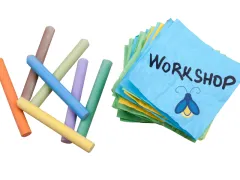 sticks of coloured chalk beside a sticky note with workshop written on it