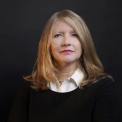 blonde woman with black sweater and white collar