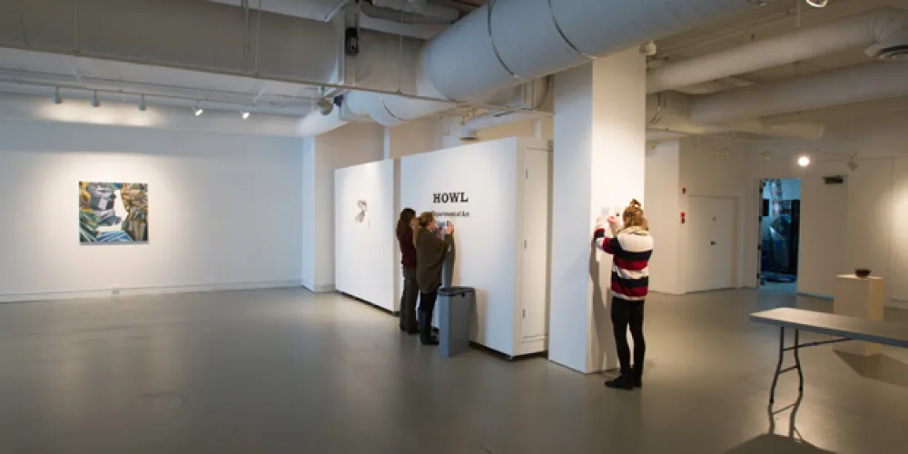 students taking down art in penny gallery
