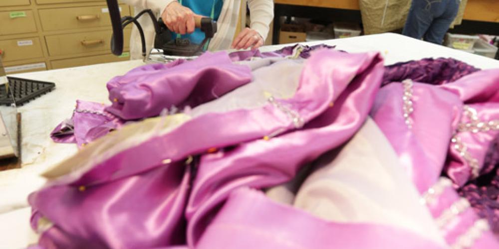 Woman ironing pink dress