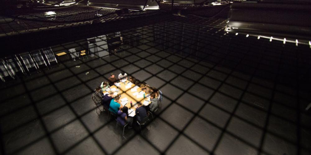 Overhead image of students in David Spinks around a table with scripts