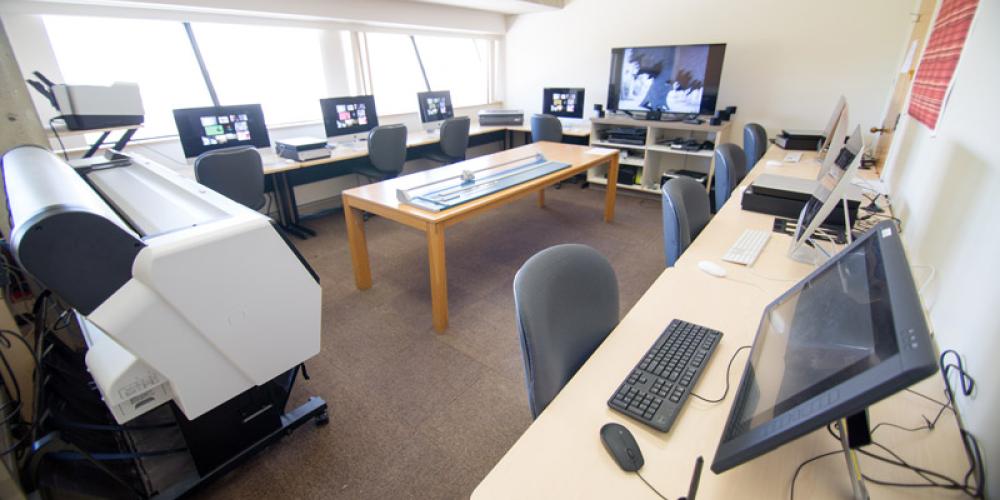 Room with computer workstations, tablets, and printers