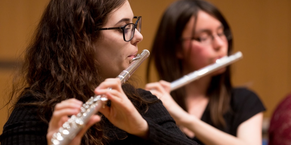 Two students playing flute in an ensemble