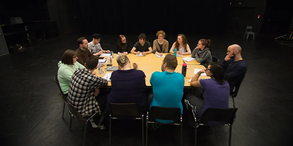 Drama students sitting around a table