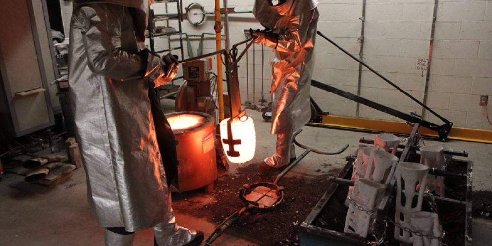students in full protectice equiment working with molten metal