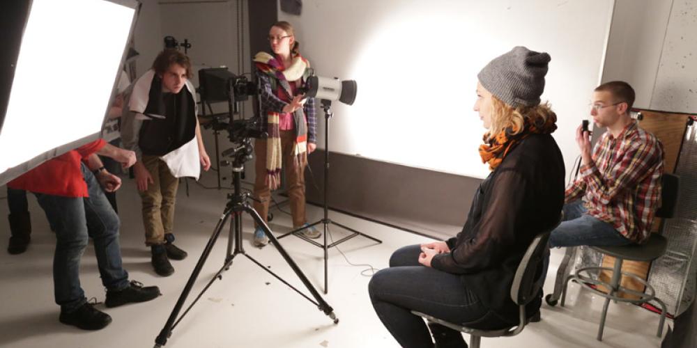 Student sitting on stool for photoshoot