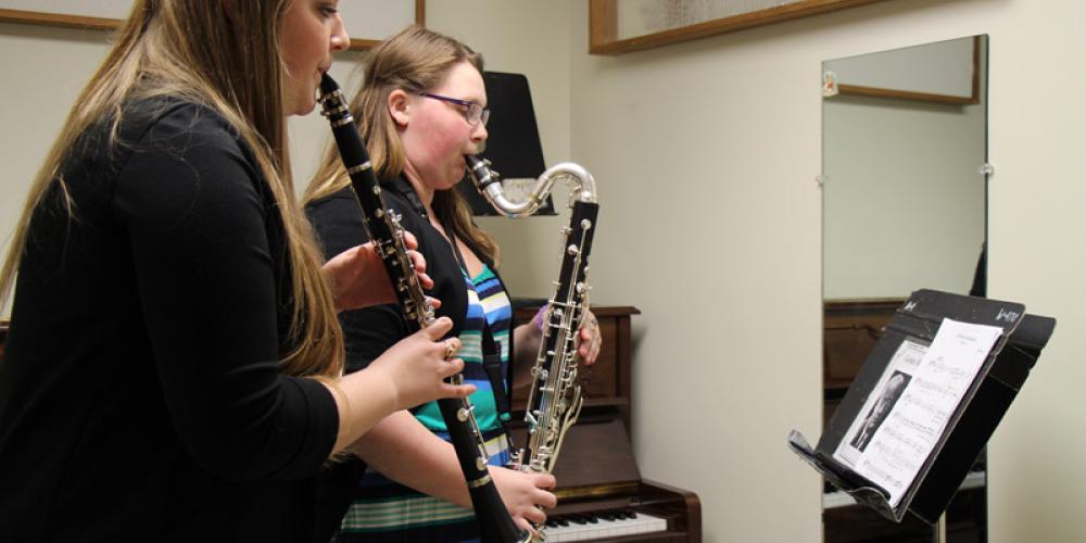 Students playing clarinet and bass clarinet in practice room