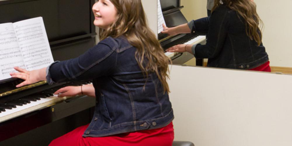 Students practicing piano and singing in practice room