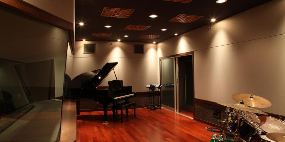 room for performers to record, with piano and drumset in room