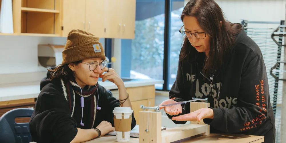 Two students beading.