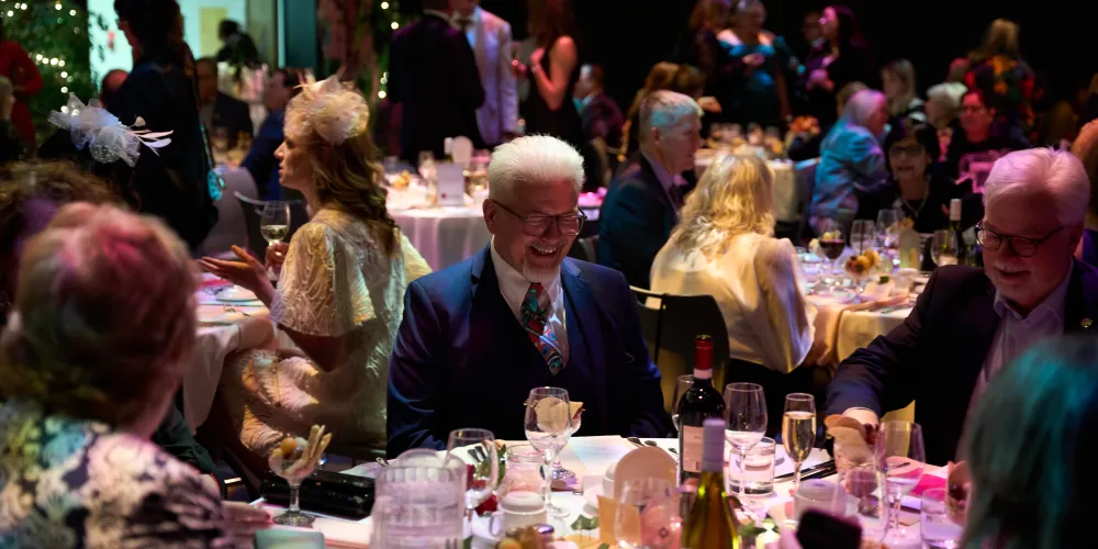Abbondanza guests sitting at a table and laughing.