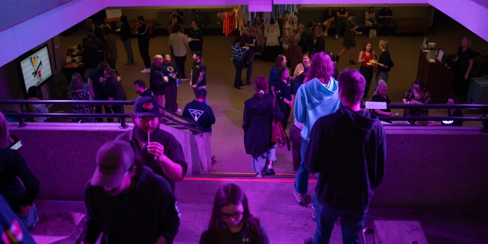 A group of people climbing stairs in purple light.