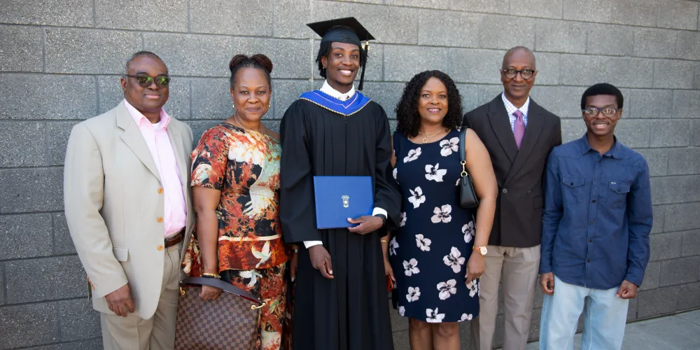 A group photo of six with the grad in the middle and their guests on either side
