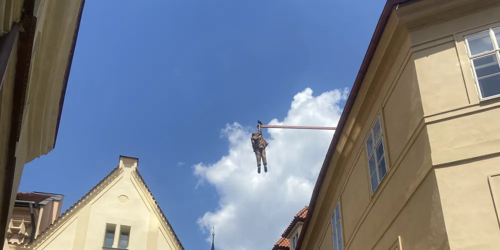 Man hanging over the street from a line in Prague