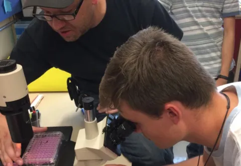 Student looking into microscope Student looking into microscope