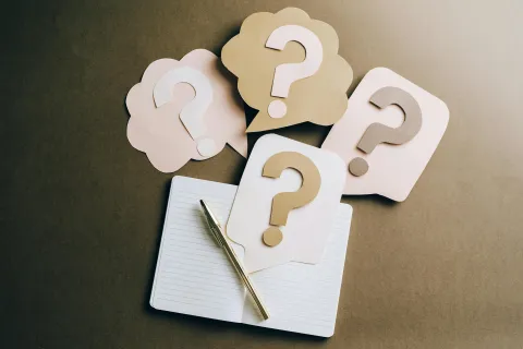 A stock image of question marks and a notebook