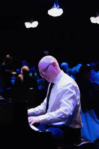 A person playing the piano at the Abbondanza fundraiser.