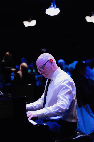 A person playing the piano at the Abbondanza fundraiser.
