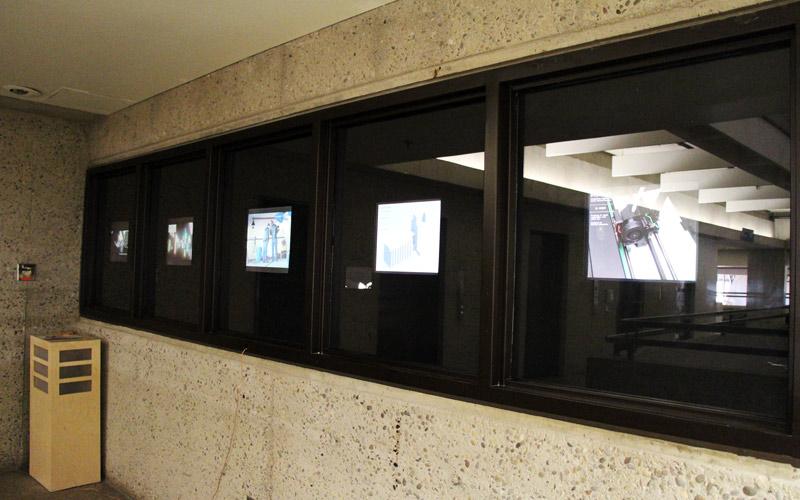 screens that face the hallway to showcase new media student work