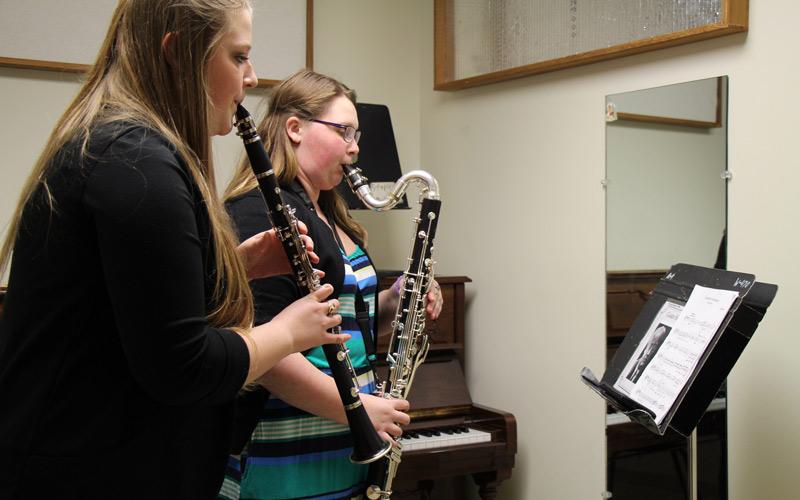 Students playing clarinet and bass clarinet in practice room