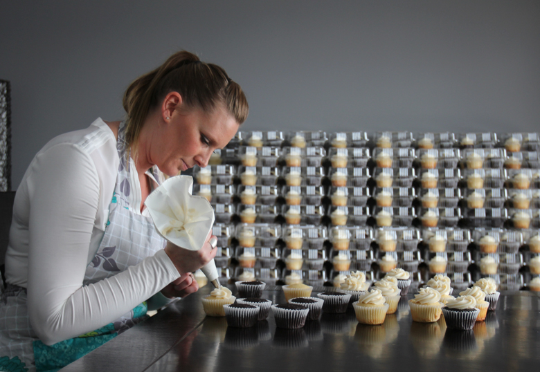 Amy Whipple of Sugar Bakeshop puts frosting on one of the cupcakes she made for the annual Cupcake Campaign